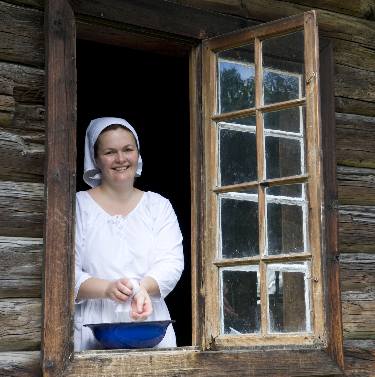 Numedalstunet. Tunvert vasker hendene i vinduet til eldhuset fra Bakke i Veggli, Rollag. Norsk Folkemuseum, 2010. 