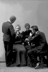 Gruppeportrett, to menn og to kvinner, røyker og ruller røyk