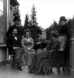 Gruppe mennesker på veranda. Avfotografert(?)