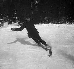 Mann i uniform kjører telemarksving.