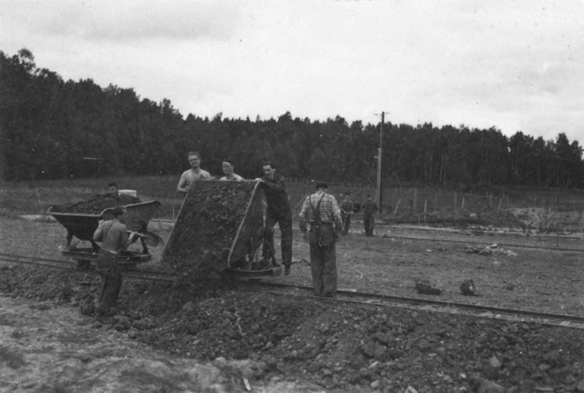 Idrottsplatsen på F 2 Roslagens flygflottilj byggs, 1943. Civilanställda tjänstemän i arbete med grävning.