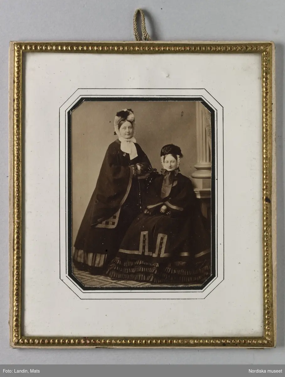 Dubbelporträtt av två kvinnor, fröknarna Hulda och Mimmi Reimers. Fotografi i visitkortsformat med passpartout och glas
Nordiska museet inv.nr 113425.