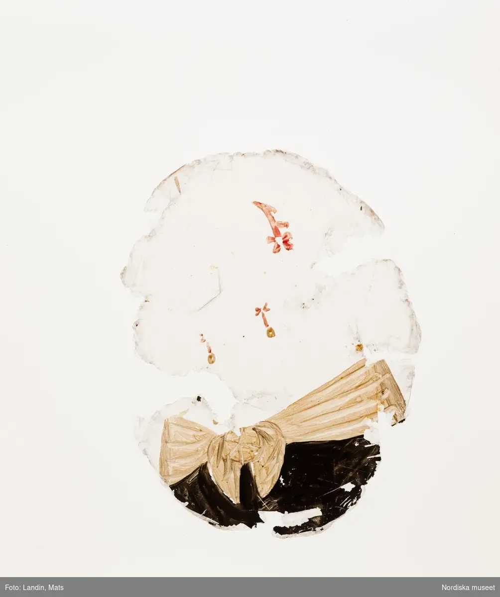 Katalogkort:
"Målning på kopparplåt, osign. Enligt uppgift av givaren föreställande en fröken Hahne. I fodral av svart pressat läder på stomme av papp med 13 glimmerskivor med målade dräkter och dräktdetaljer enligt uppg. målade av prof. N. H. Sjöborg (1767-1838)."
"Blont hår, mörkgrå ögon, rosafärgad klädning besatt med vita spetsar och spetskrage, vitt pärlband i hår och om hals, dessutom juvelhalsband och juvelbrosch. Bakgrund t.h. brunt draperi (vägg?) t.v. träd mot molnig blå himmel, 2 flygande fåglar. Kopparplåten genomborrad upptill. Till detta höra 13 st glimmerskivor att lägga på målningen. I svart ovalt etui, 88 mm x 73 mm av svart refflat skinn, invändigt klätt med ljusblått siden."

Genom att lägga de olika målade glimmerskivorna ovanpå porträttet förändras Kerstin Hahnes utseende. Skivorna visar enligt katalogkort:
- vit turban virad med gulbrunt, ljusbrun draperad dräkt med svarta prickar
- svart huvudbonad och gula örhängen
- svart huvudbonad, ljusröda örhängen, ljusröd bröstrosett
- svart hatt, svart kort jacka, vit krage och vita ärmar synliga i uppslitsningarna
- svart dok och klädning, vit krage
- ljusröd hårprydnad, örhängen vita och ljusröda, svart klädning med vit krage
- ljusbrunt hårnät, dito örhängen med vita pärlor, ljusbrun klädning med vita ärmar
- vitt nunnedok, svart dräkt
- ljusbrun hårprydnad, möjligen nät av band, vita örhängen, svart klädning, vit krage
- brun huva med krage, möjligen kappa
- svart barett med en grön, en vit och en rosafärgad plym, fästade med en gul agraff, vita örhängen, vit bröstrosett
- hårklädsel av 3 gula fjädrar samt en gul, en vit, och en grön plym, svart mask, vita örhängen, vitt band som täcker hakan, två gula bröstrosetter
- hårprydnad (nät?) ljusrött, röd och vita örhängen, till venster en neger, som omfamnar damen, under negerns huvud något gulvitt, som möjligen tillhör hans dräkt

Kerstin Hahne, död 1656, gift med Honorat Verdelet, var dotter till uppvaktaren hos kung Karl IX:s barn, Christoffer Hahne till Hesselby och Ingrid Björnsdotter.