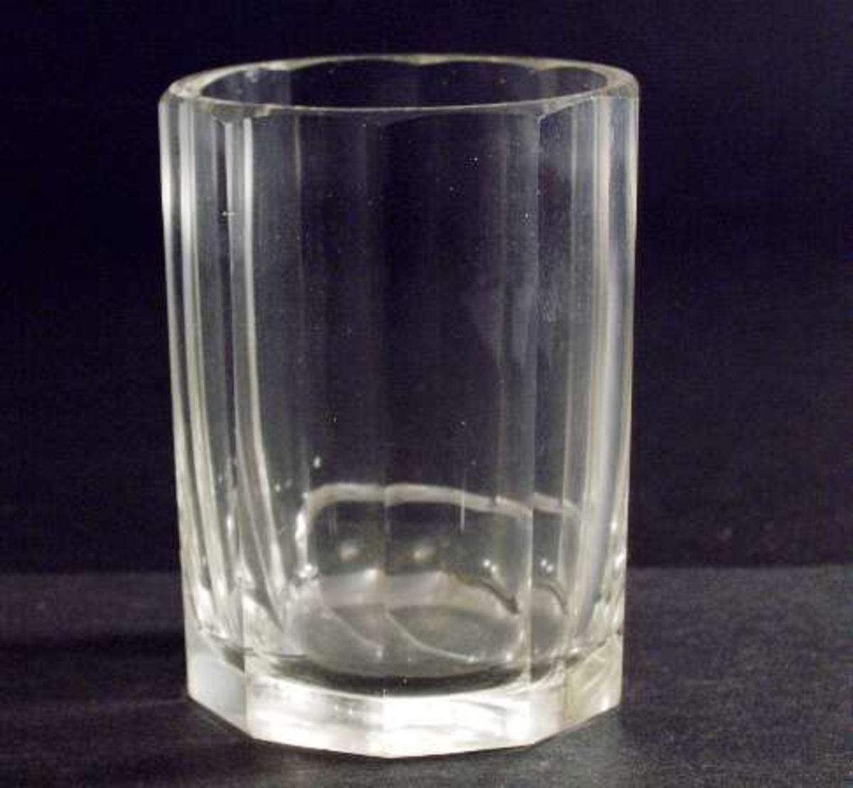 Två dricksglas av tjockt ofärgat fasettslipat glas, så kallad mormorsslipning. Glasen raka, 10-kantiga.