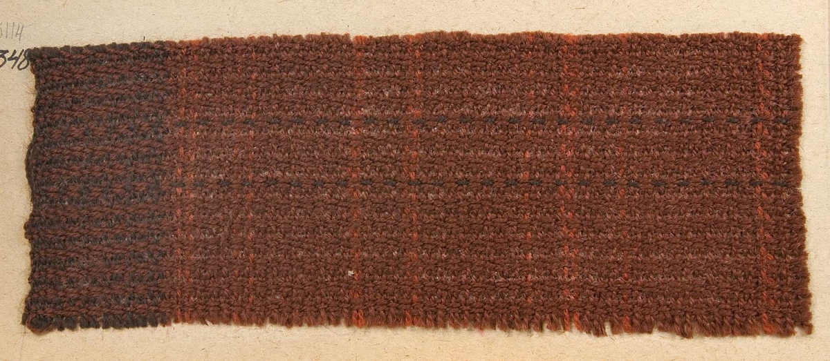 Vävprov ämnat för draperityg vävt med ullgarn i rödbrunt. Vävprovet har nummer "B-1348".