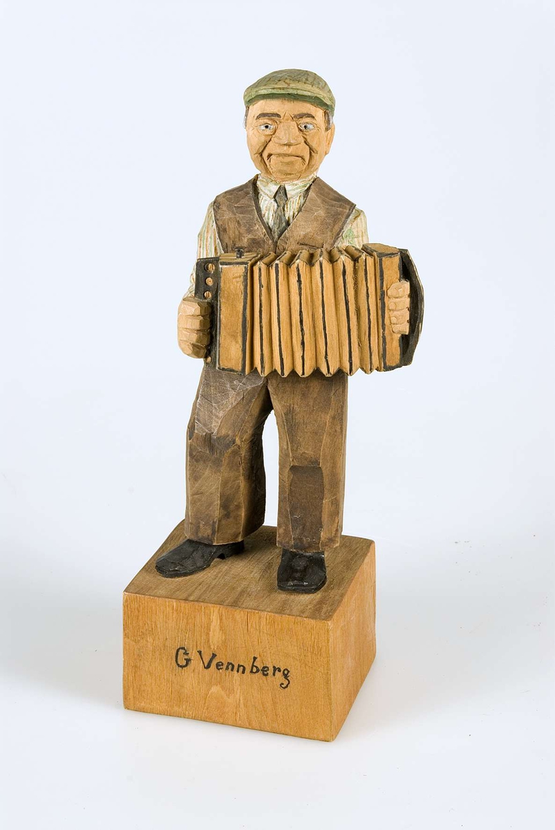 Figur av trä föreställande spelmannen Gustaf Vennberg spelandes dragspel.