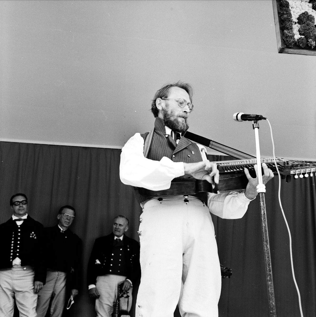 Spelmannen Hans Gille med nyckelharpa på Upplandsschottisen, Tierpstrakten, Uppland 1973. I bakgrunden bl a spelmannen Eric Sahlström