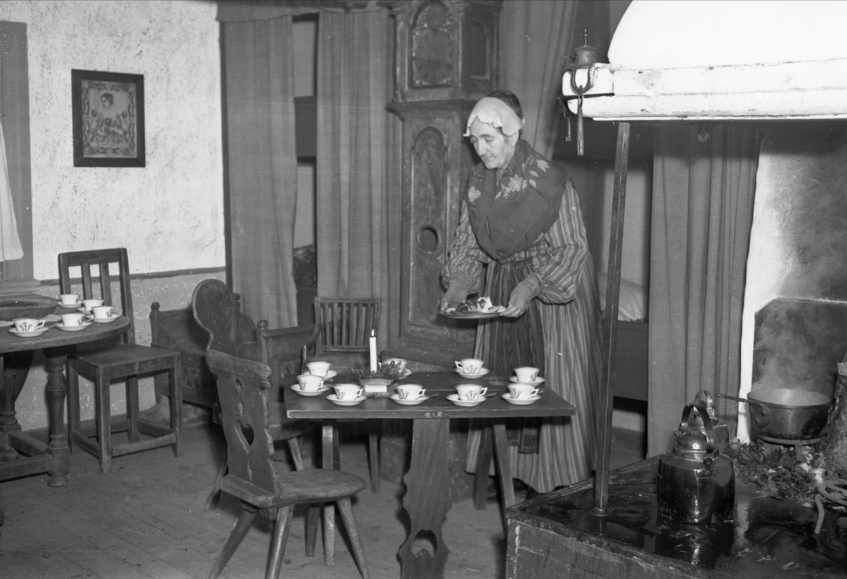 "Disagården rustar till julmarknaden" - Gamla Uppsala november 1951. Aina Carlsson förbereder kaffeserveringen i Nyvlastugan
