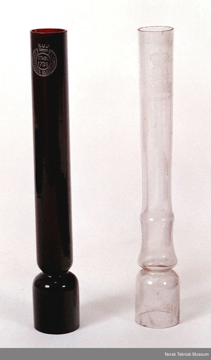 Liten kobberfot med parafinskål og plass for veke. Ifølge gjenstandskort hører ett blankt og ett rødt lampeglass til. 