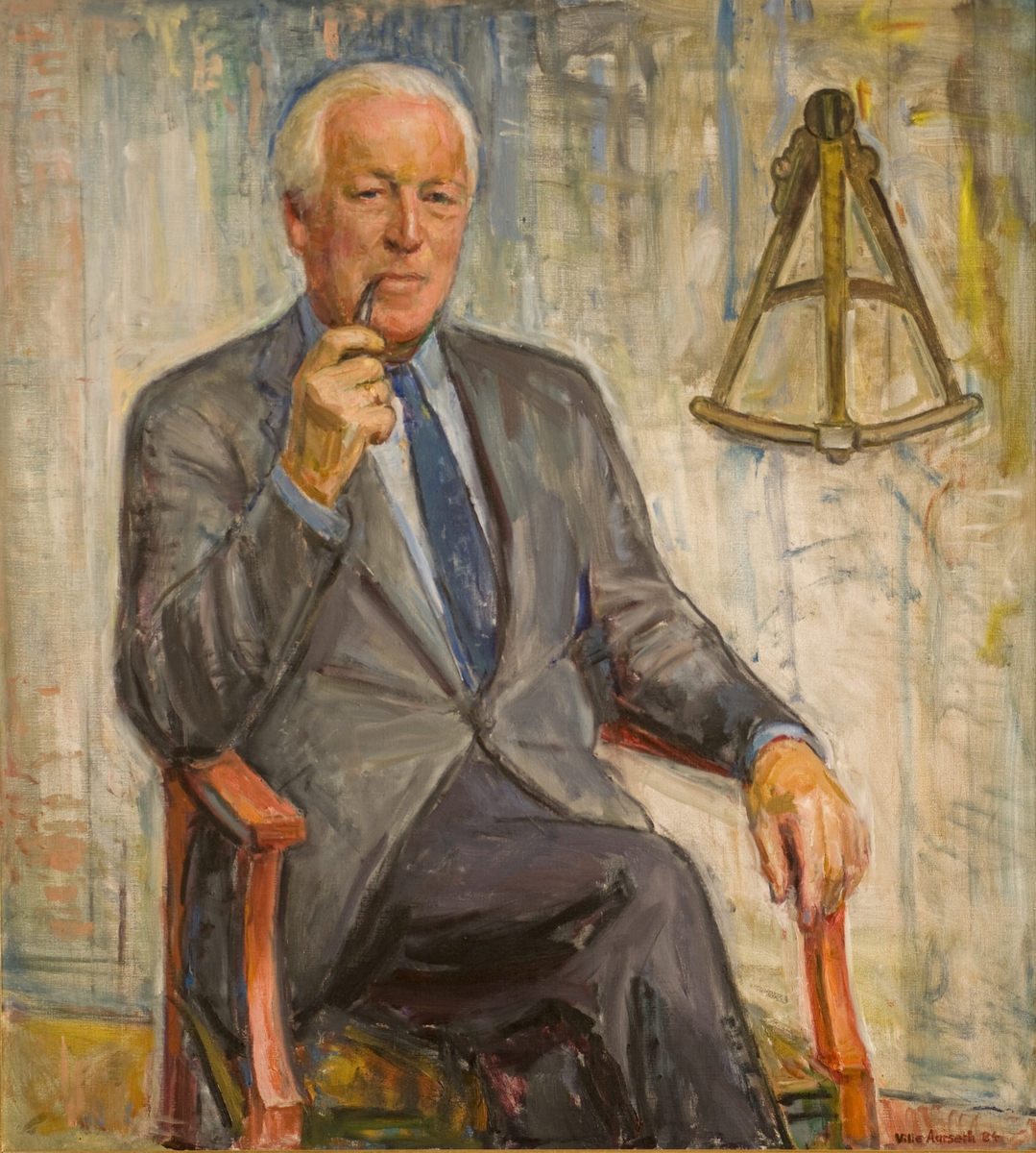Portrett av museumsdirektør Svein Molaug, sittende i stol, røykende på en pipe. 