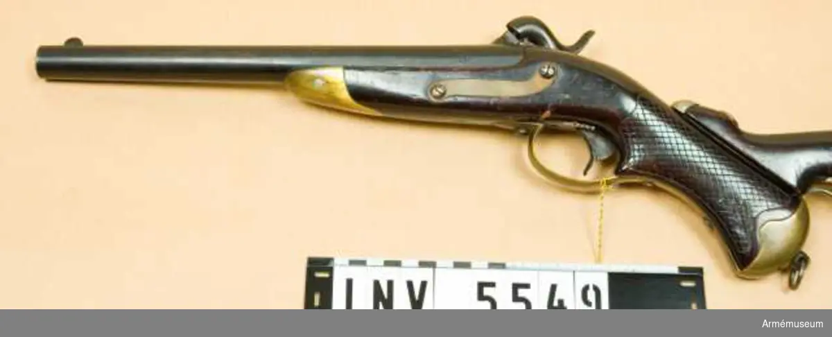 Tappstudsarpistol med slaglås.
Rund pipa. Brungjord. Låset gråhärdat. Låsblecket är märkt med faktoriets stämpel tillv.år 1856.