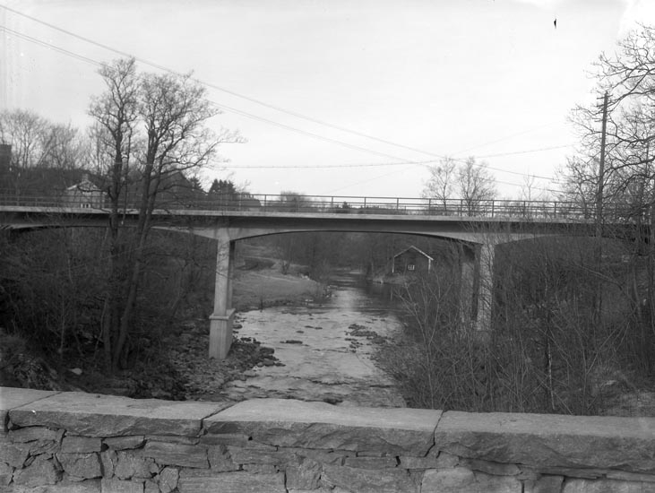 Enligt medföljande noteringar: "Den ombyggda bron vid Herrgården omkring 1943 från båda sidor."

Uppgifter från Munkedals HBF: "Fotot taget från gamla stenbron. Huset i mitten i bakgrunden sadelmakarboden. Munkedalsälven."