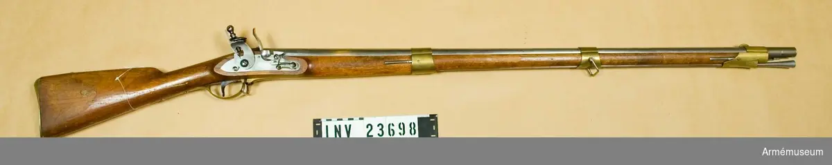 Samhörande nr är: 23698-99 gevär, bajonett.Gevär m/1815, infanteriet.
Grupp E II. 
Kallat 1815 års första modell.Överlämnad enl.KAAD skriv. 11/12 1880, dnr 469. Jfr. AM 1932:7483.
