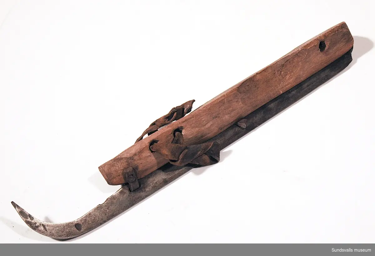 Ett par skridskor med fotstöd i trä, skena i smitt järn och läderremmar. 1800-tal.