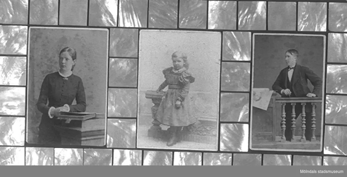 En tavla med tre porträtt föreställande Andreas Benjaminsson med makan Beata f. Lindbäck och dottern Anna, född 1893 i USA. Makarna utvandrade till USA 1886. Ram av pärlemor som användes vid inläggning i möbler. Tillverkad av Gunnel Knuthén.