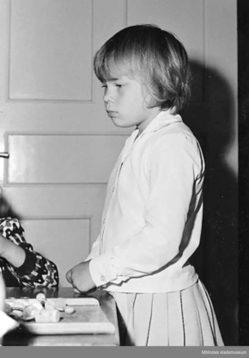 En flicka står vid sidan av ett bord. Holtermanska daghemmet 1953.