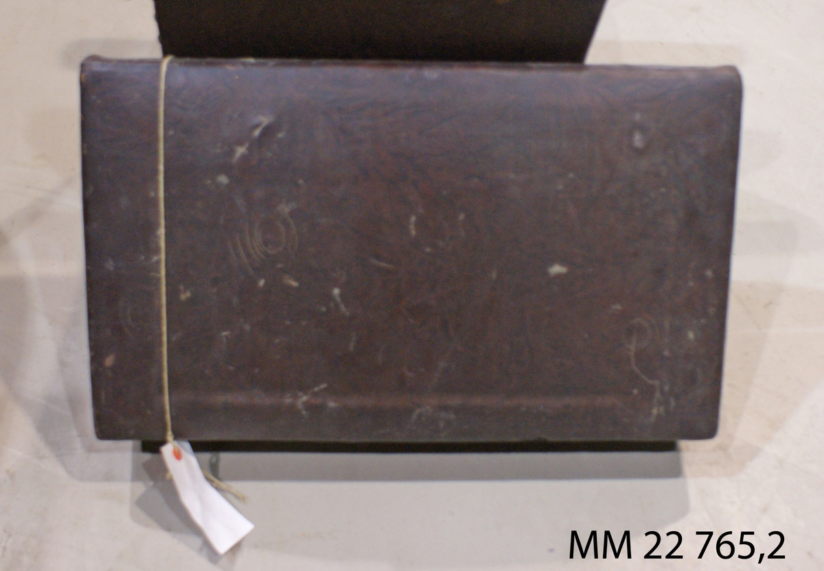 Fåtölj av svart läder på trästomme, med ryggstycke, stoppad, väggfast.
:1 Fåtölj
:2 Ryggstycke
SSS 38,2.