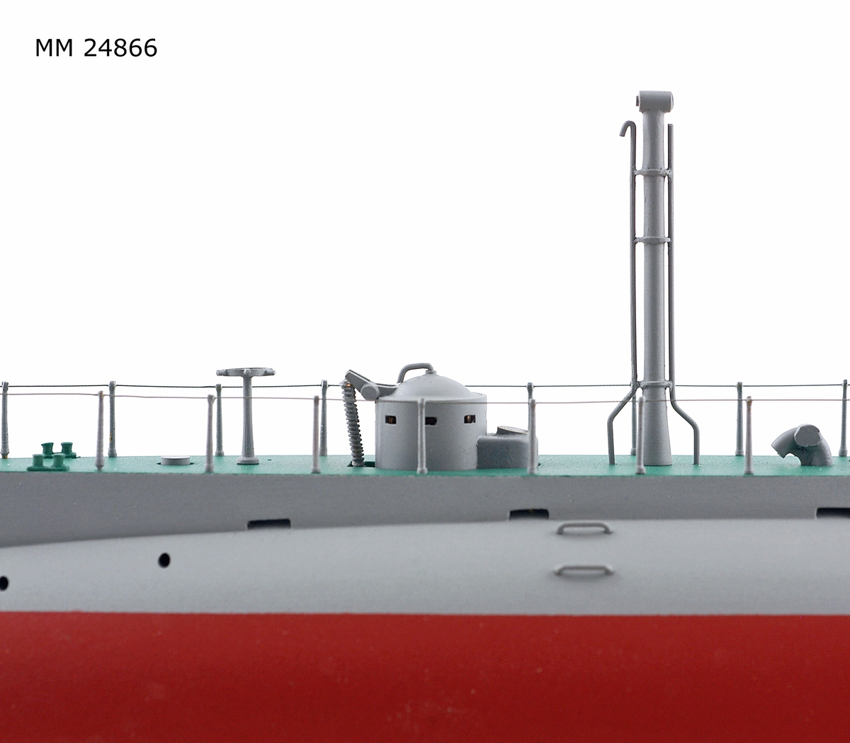 Ubåtsmodell Hajen i monter. Modell av alträ med detaljer av mässing, målad med cellulosafärg. Rött och grått skrov. Monter av plexiglas på träplatta. Mässingsbricka i montern med uppgifter om modellen.