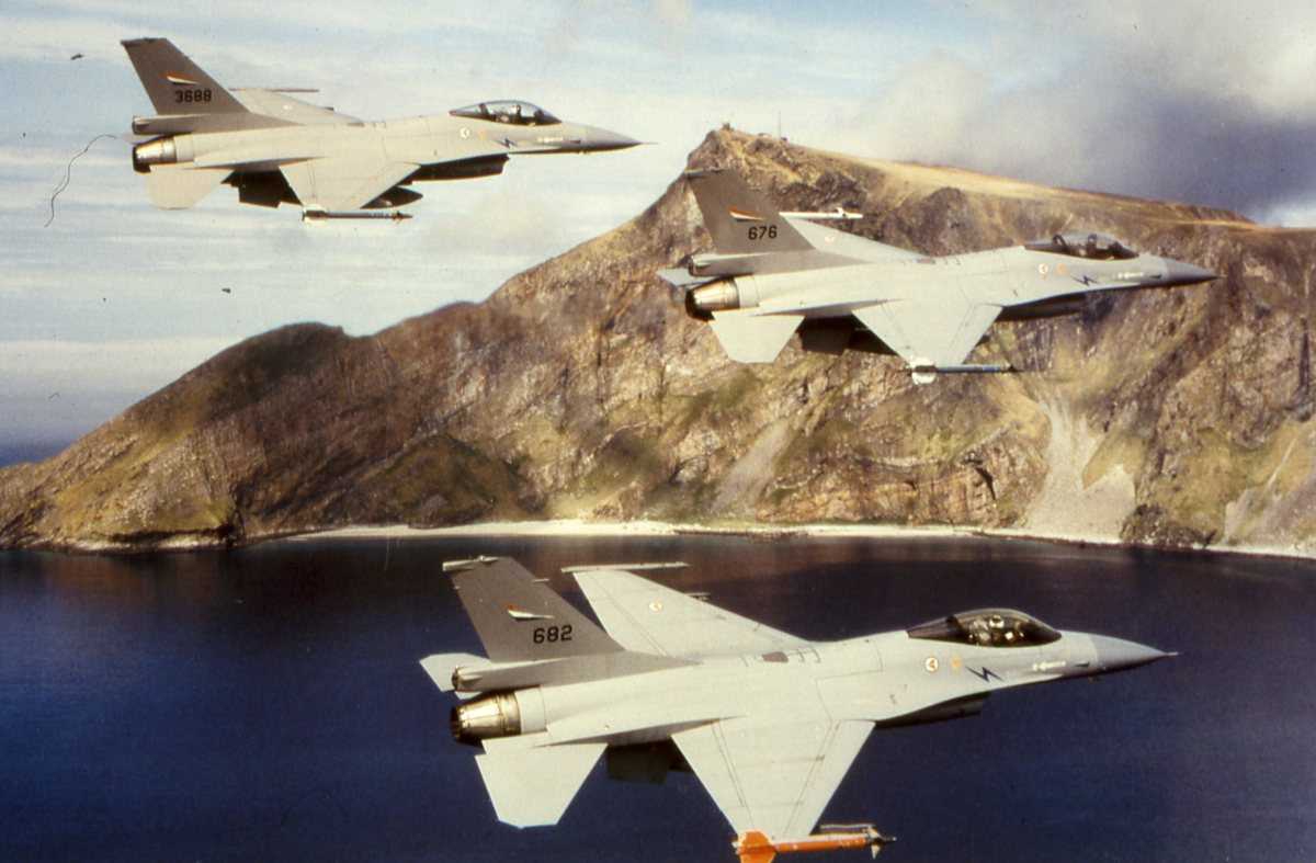 Norske fly av typen F-16 Falcon med nr. 682 nærmest, nr. 676 og lengst vekk nr. 3688. I bakgrunnen sees Værøy med Sjøforsvarets stasjon på toppen.