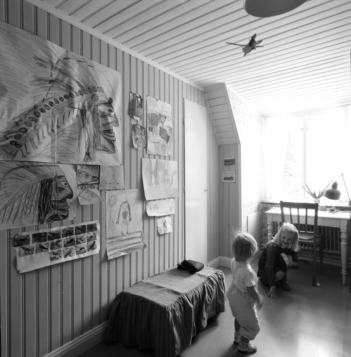 villa Ahlgren
Interiör av barnkammare med två små barn, på väggen barnteckningar.