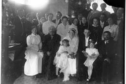 Et brudepar omgitt av familie og gjester.