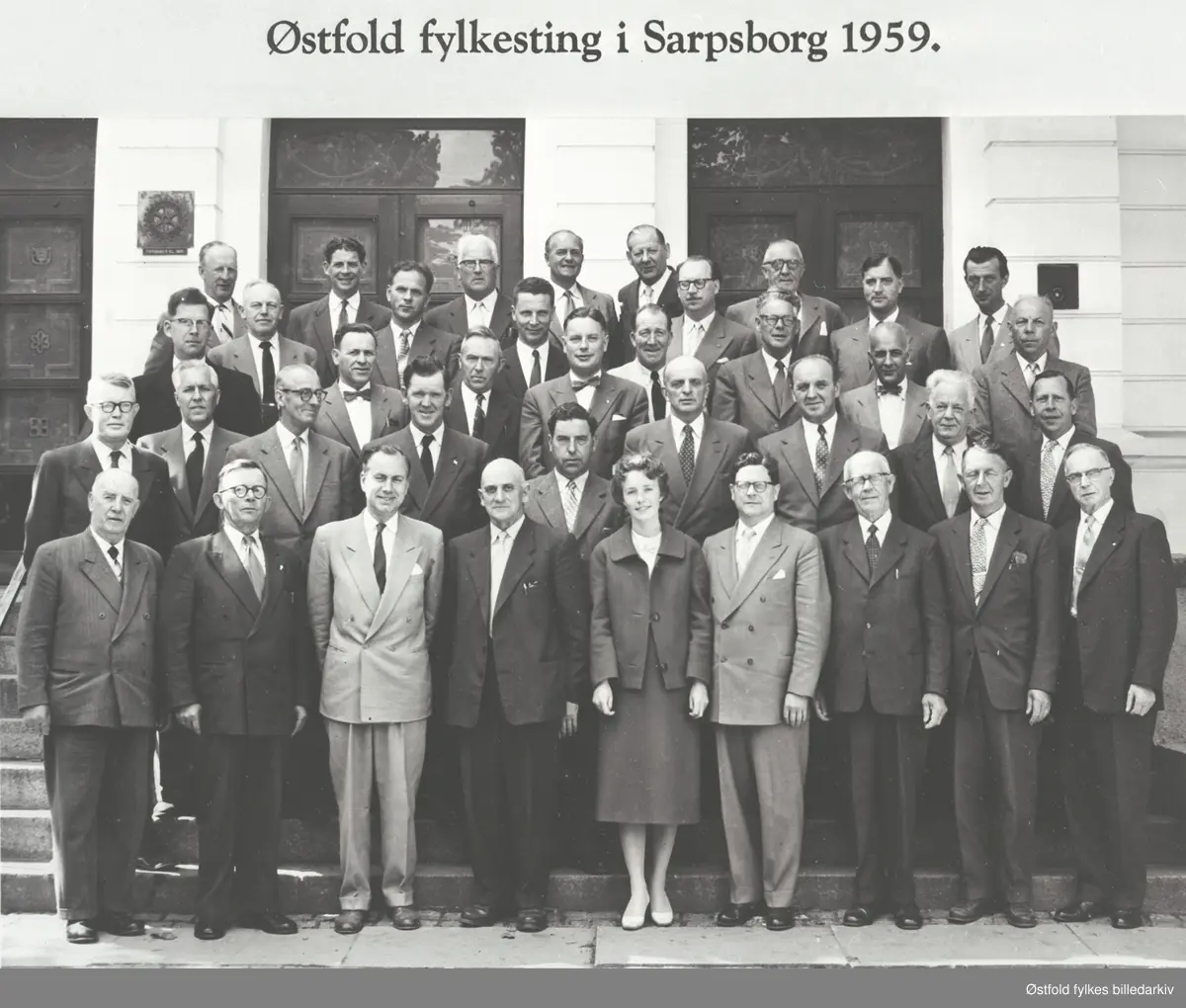 "Østfold fylkesting i Sarpsborg 1959." 

Første rekke fra venstre:
1. Johan Jensen
2. Marius Nakkim
3. Henry Brattberg
4. Robert Frorud
5. Liv Meum
6. Asbjørn Listerud
7. Hans Kristiansen
8. Anker Olsen
9. Olaf Skramrud

Andre rekke fra venstre
10. Karl Hess, fylkesmann
11.Harald Bjelke, fylkeslege
12. Karl H. Karlsen, formann
13. Paul Røtne
14. Wilhelm Thøgersen
15. Boe Guren
16. Johan Volden
17. Rolf Ytrehus

Tredje rekke fra venstre.
18. Arne Bergli
19. Einar Lund
20. Johan Stenholt
21. Johan Gjestang
22. Haakon Vamraak, fylkeskontorsjef
23. Erling Andreassen
24. Ole Kraggerud
25. Rolf Sjø Hansen
26. Johan Brække
27. Amund Larsen
28. O. Benterud, vegsjef
29. Thorleif Nilsen
30. Einar Brusevold
31. Lars Krog, formann
32. Helge Sivertsen, skoledirektør
33. Johan Andreassen
34. O. Steen-Larsen, fylkesrevisor
35. Reidar Skordal, fylkesarkitekt
36.Olaf Steen
37. Johan Lyche
38. Ingvar Bakken