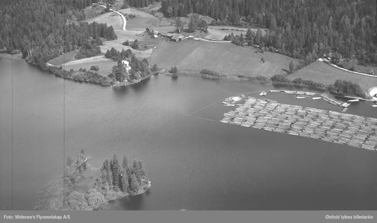 Oversiktsbilde fra  Bottenvika, Otteid ved Øymarksjøen i Marker. 
Tømmerklave fortøyet. Sannsynligvis Grislingås gård i bakgrunnen.