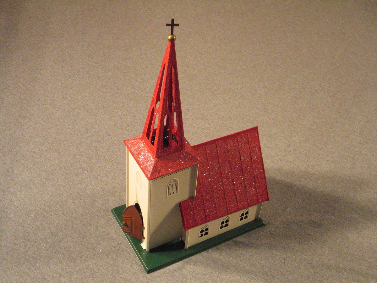 Utanpå øskja ei teikning av kvit kyrkje med raudt tak. Kristtorn
