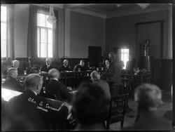 Gruppe menn, rettssal?, fotogr. navn på skrevet på plate