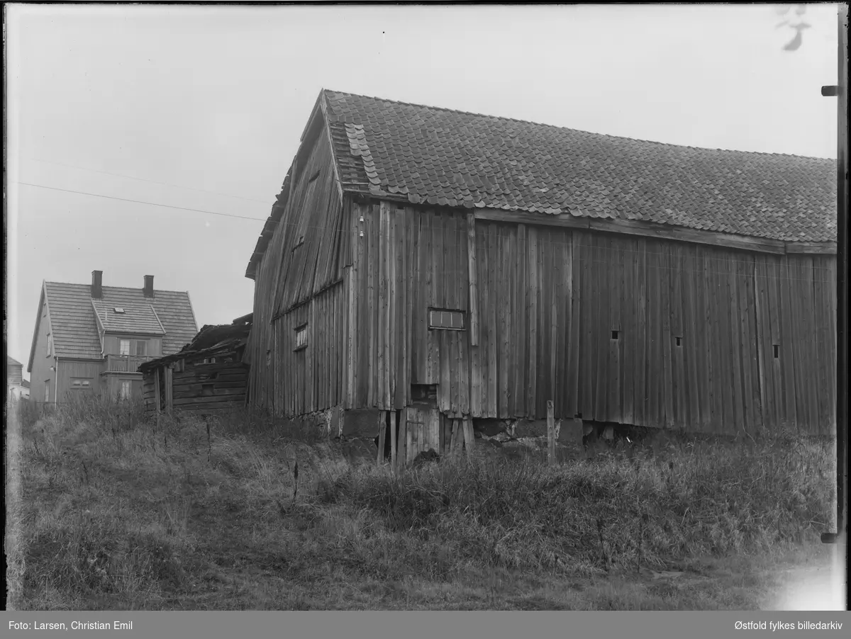Uthus, ant Sarpsborgdistriktet, 1932-33, ukjent sted, forfallent. Våningshus i bakgrunnen.