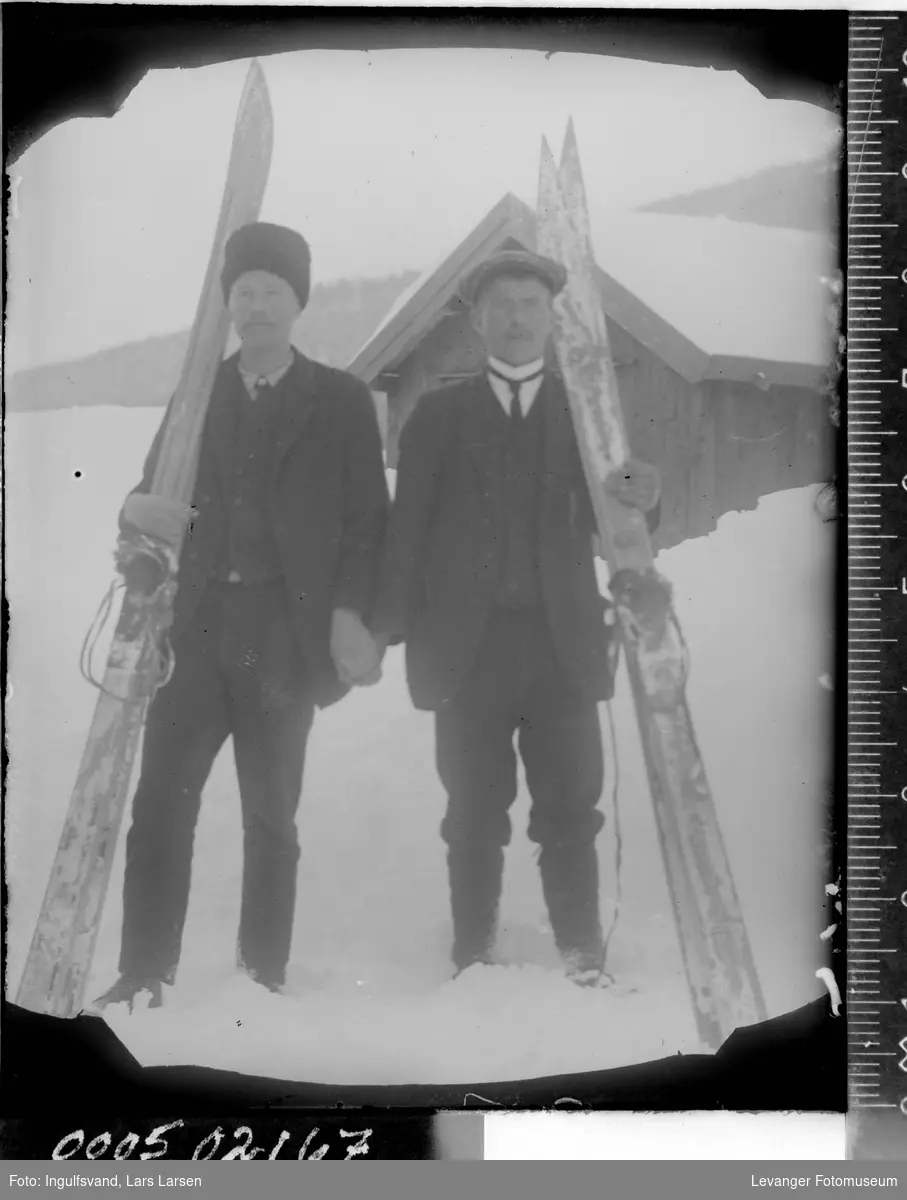 Portrett av to menn med ski.