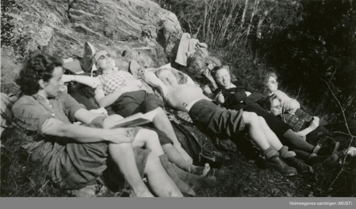Ungdommer soler seg ved en bergeknaus.