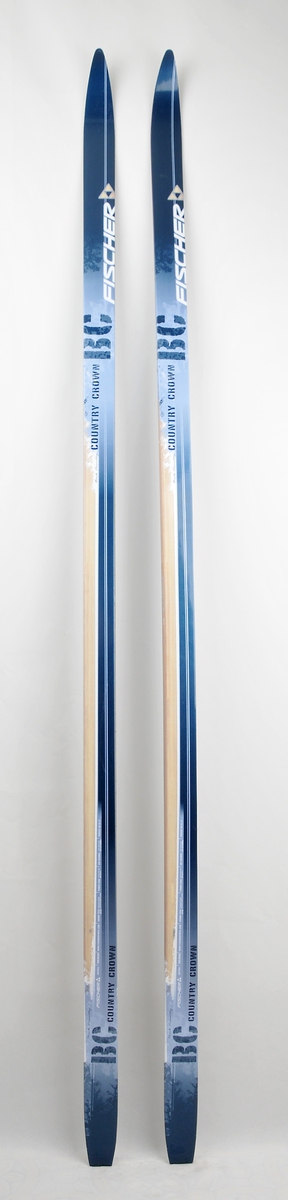 Langrennski laga av glasfiber. Svart smørefri såle med riflemønster. Blå overflate med dekor som imiterar tre.  

