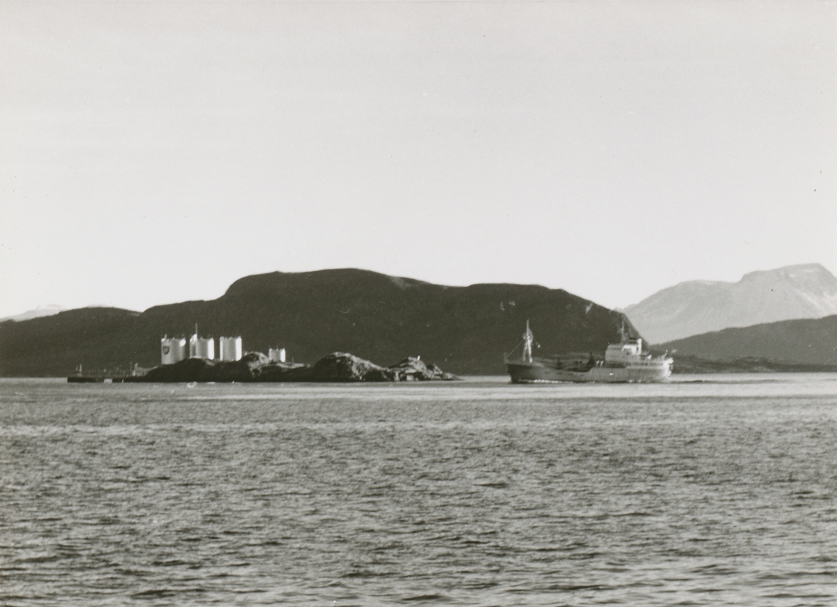 Prospektfotografi av Valderhaugfjorden med Kjeholmen og et lasteskip i forgrunnen. Ellingsøy ses i bakgrunnen.
