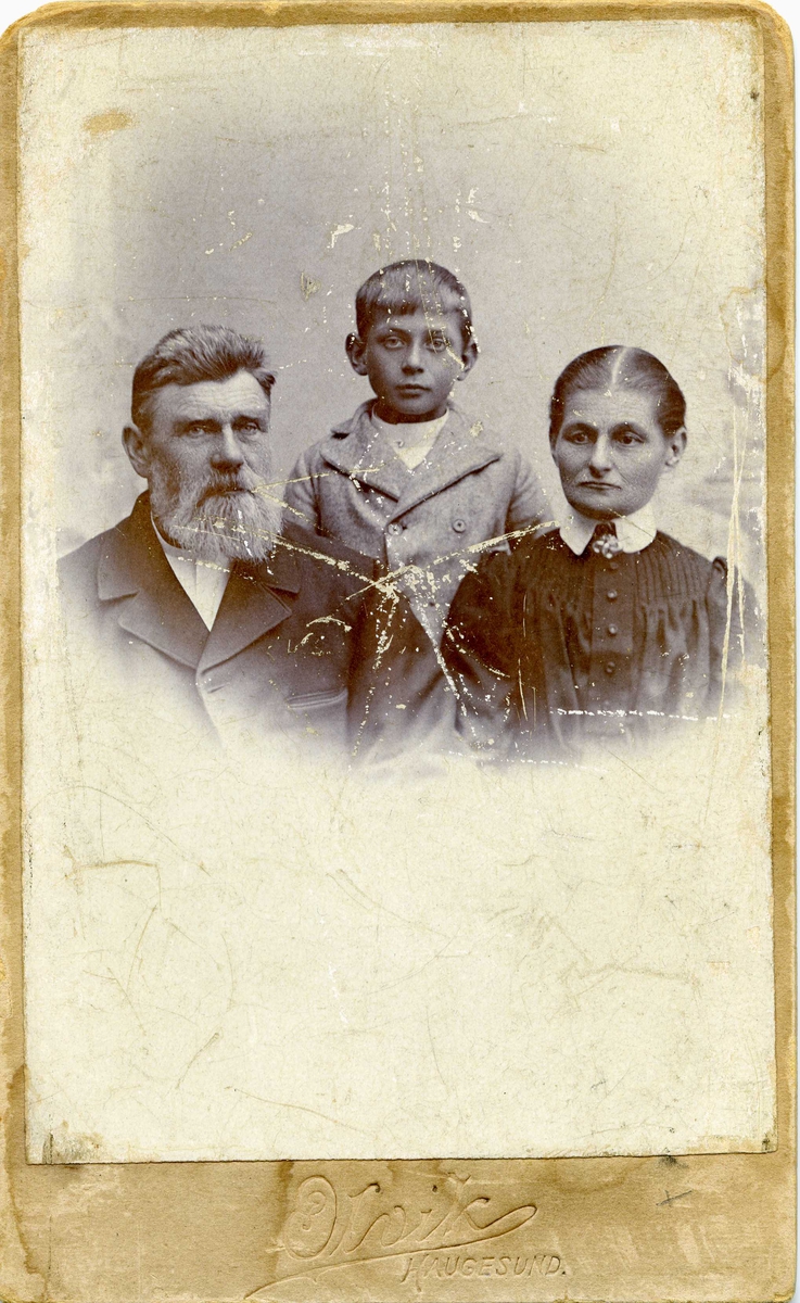 Portrett - Herre med skjegg, dame og et barn.