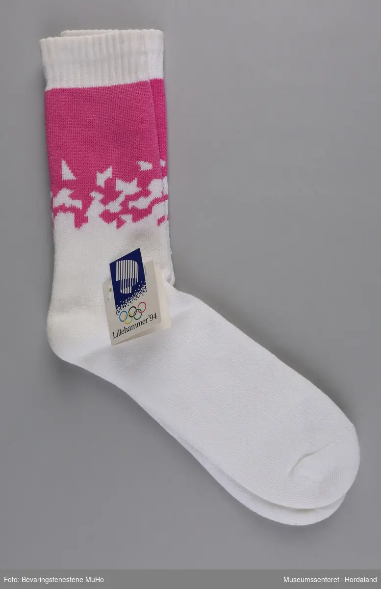 Eitt par kvite frottésokkar med rosa mønster. Sokkane vart produserte til Vinter-OL på Lillehammer i 1994.
