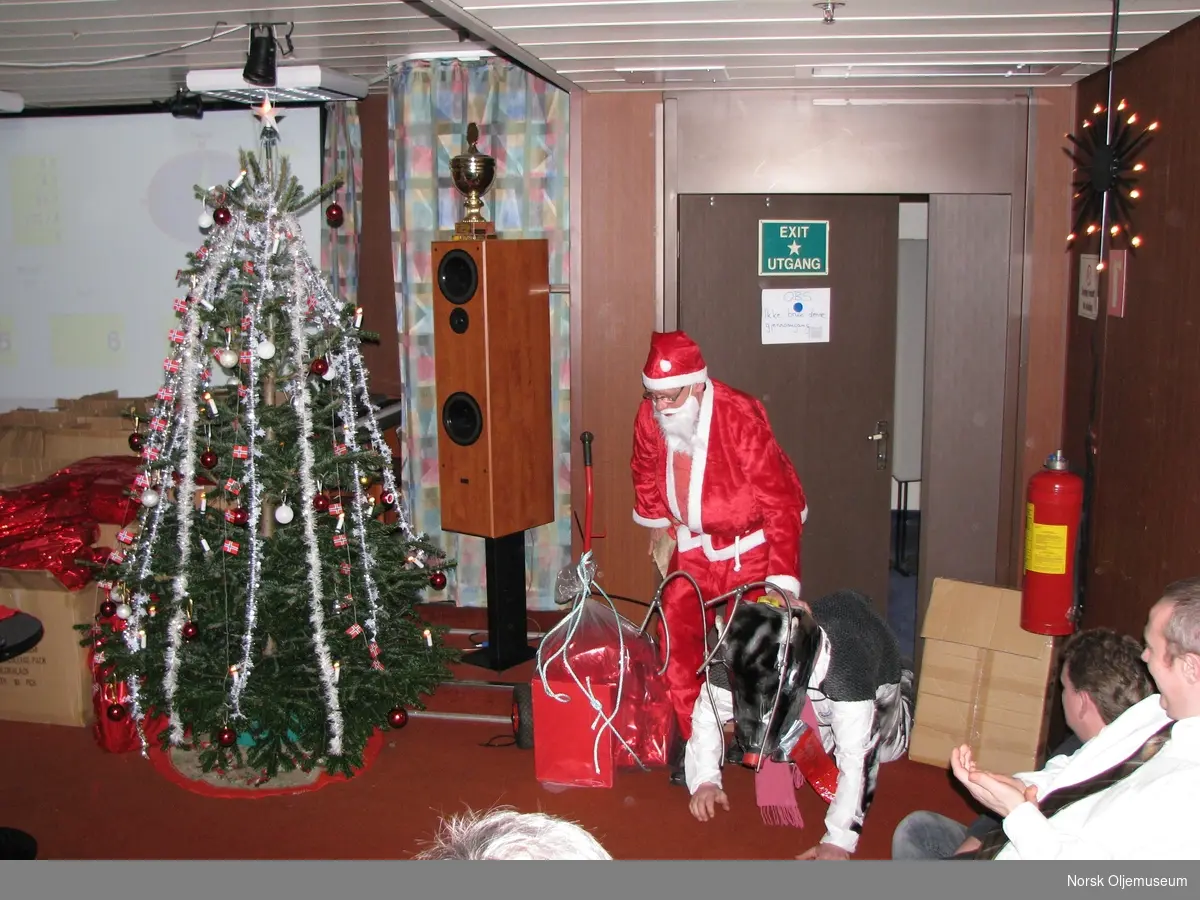 Julenissen kommer inn i kinosalen med et "reinsdyr" og gaver.