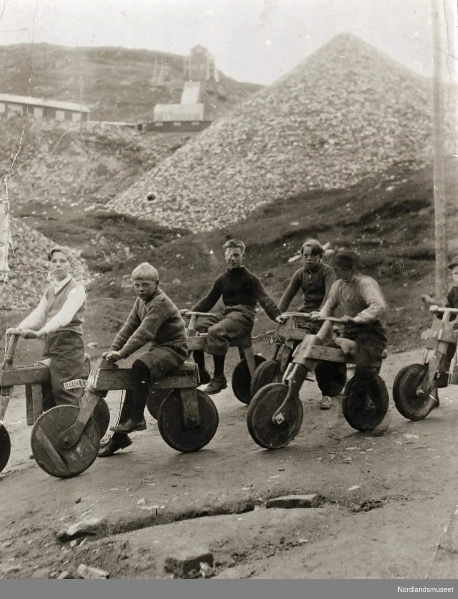 5 gutter på hjemmesnekra sykler foran gruveområdet. Syklene var laget av plankerester og hjul av lokk fra karbidtønne. Disse sykkelpatentene var i bruk også på 40-tallet.