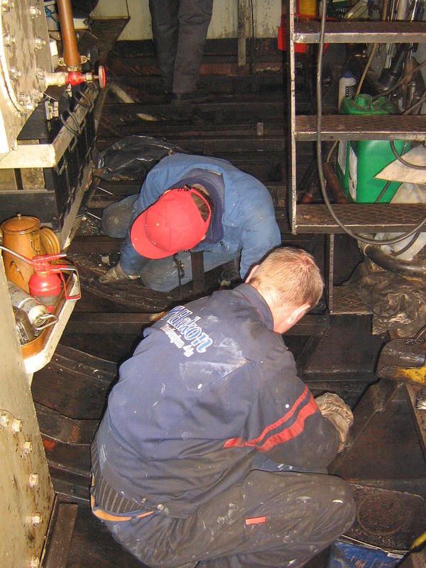 Foto av personer som arbeider i maskinrom på båt.