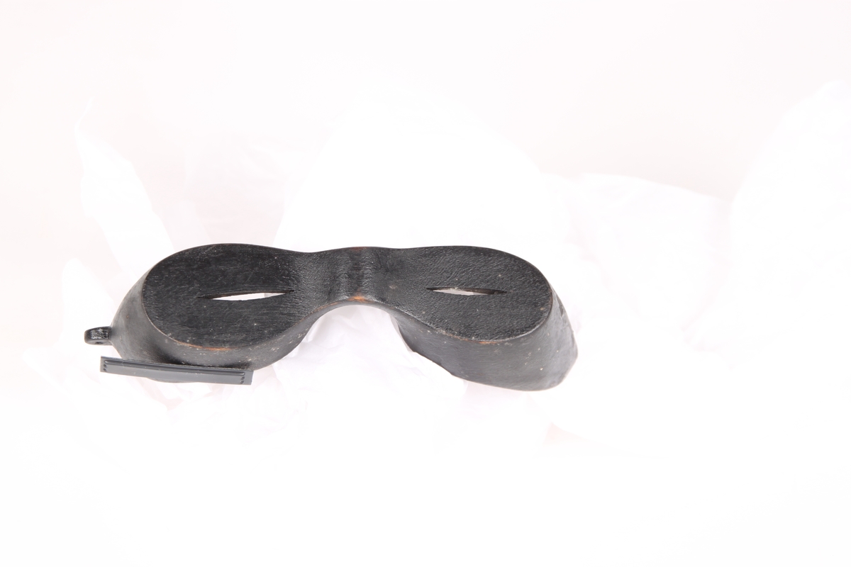 Snøbriller til beskyttelse mot snøblindhet, i lett balsatre. Det er et hull til feste av snøre på hver side av brillen.