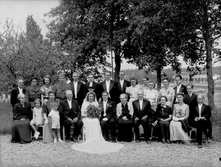Bröllop, brudpar och bröllopsgäster.
Tvåvånings bostadshus i bakgrunden.
Brudparet Dagny Källén och Gösta Blixt.
Midsommarafton (1941-06-23).