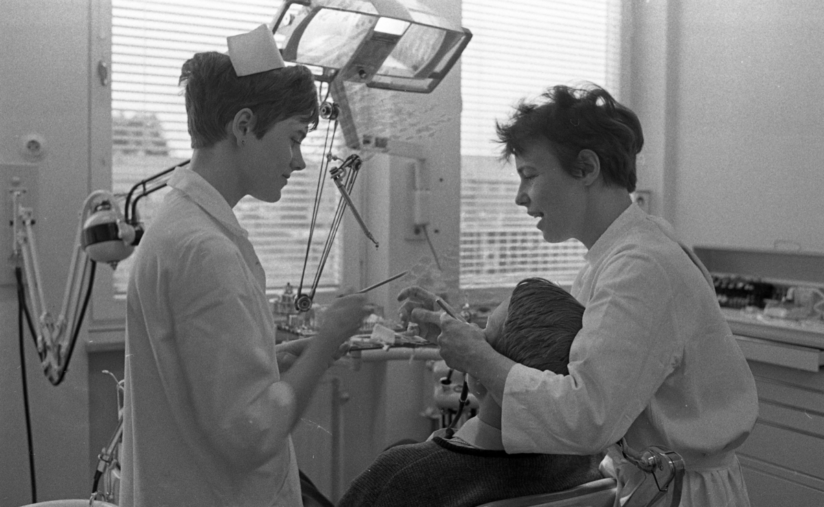 Fellingsbro tandklinik 8 april 1968Tandläkare gör tandvård på en pojke, och en tandsköterska assisterar henne.