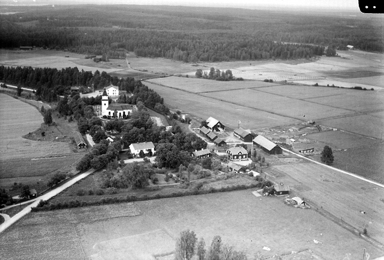 Flygfoto över N. Lunger, kyrkobyggnad, bostadshus och byggnader.