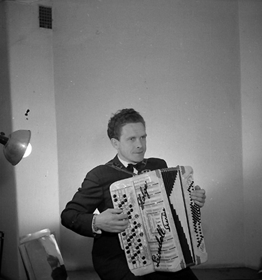 En man med musikinstrument (dragspel).
Holger Lindell