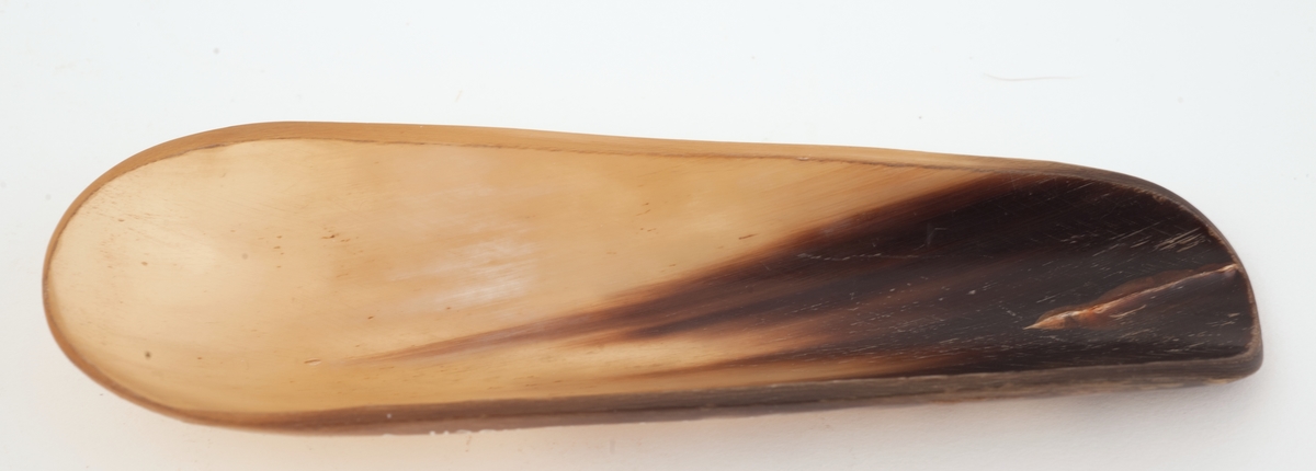 En båtlignende form av horn med den ene enden noe smalere og flatere for lettere å kunne dyttes inn i en papirkapsel.