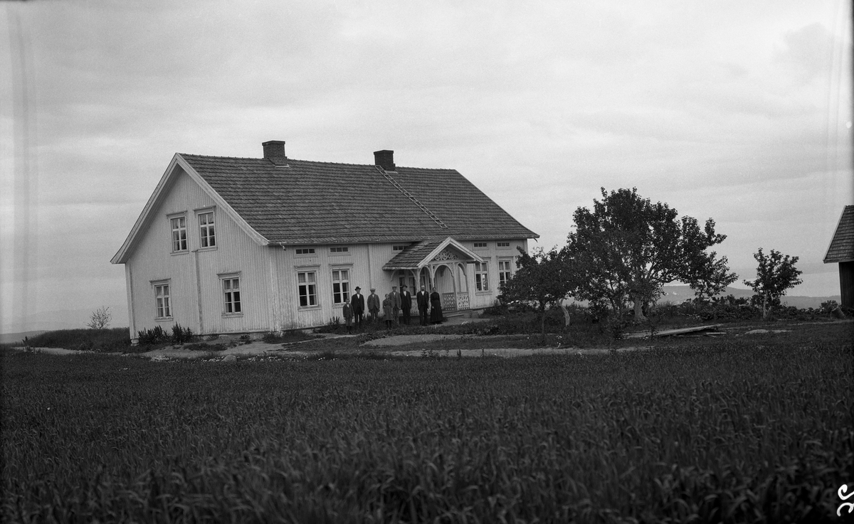 Bruket Skullerud i Øverskreien, Østre Toten. To bilder. På det ene ser vi Helga og Johan Albert Skullerud med deres 6 barn. F.v.: Arne (1909-2006), Josef (1898-1935), Oskar (1905-1984), Hilda (1909-1991), Kasper (1902-1990), og August (1900-1988., Lengst til høyre, Johan Albert (1865-1947) og Helga (f. Holmstad) (1869-1950).