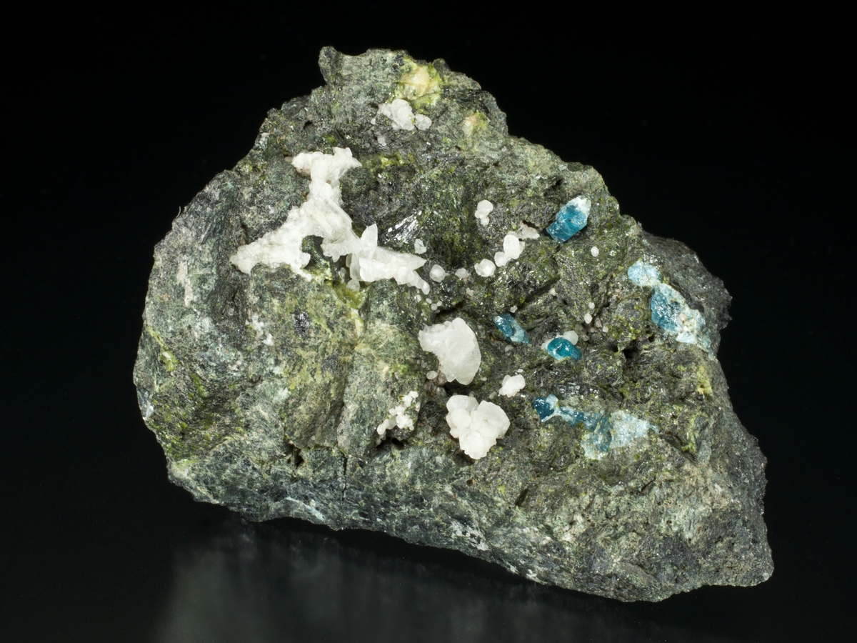 Apatitt, blå, translucent, på matriks. (med hvit kalsittkrystaller, ægirin(?)krystaller, magnetitt + epidot(?).
Gammel etikett "Monoxiit xx. 1800-tallet? Senere 4142 på baksiden.