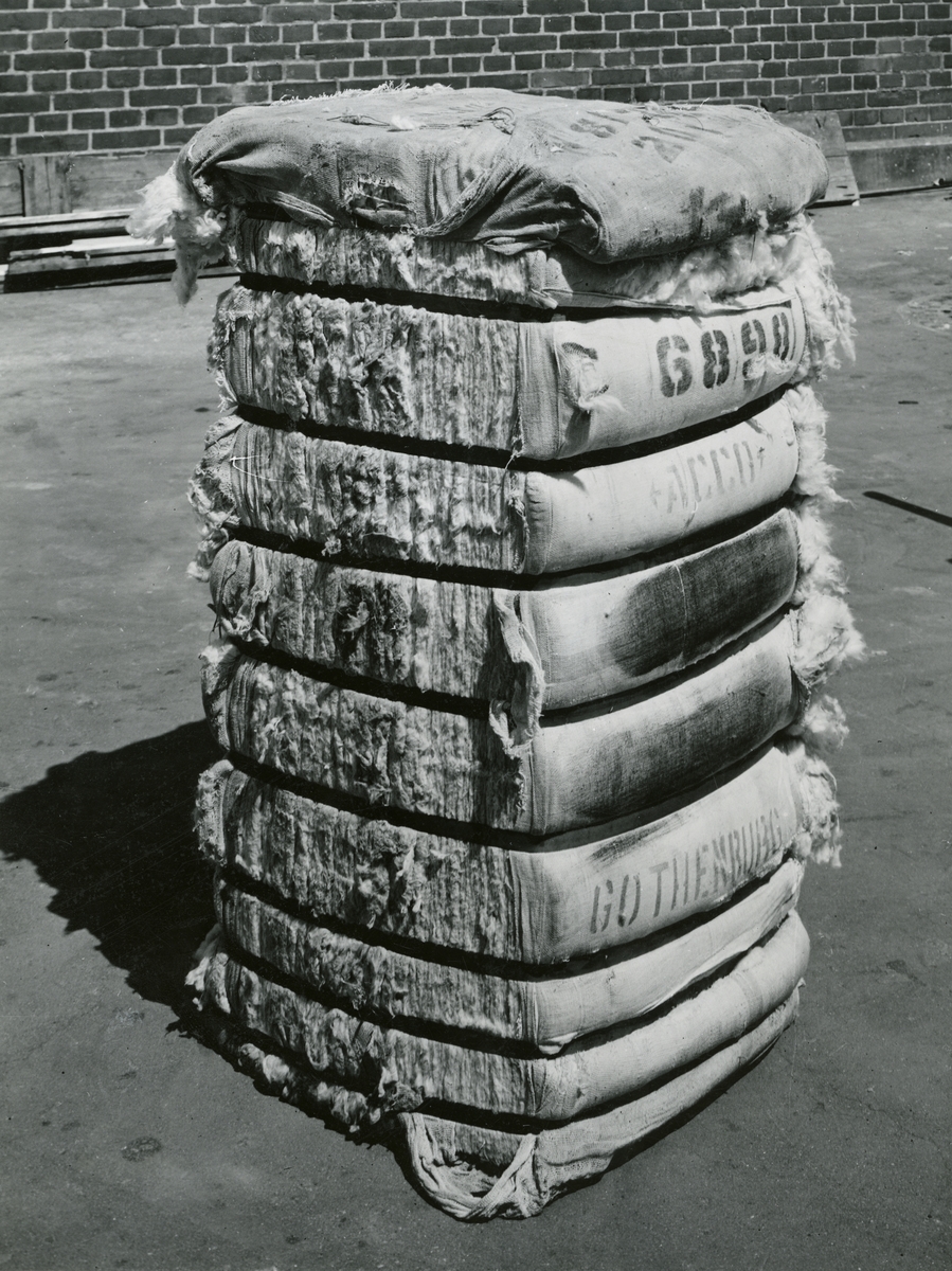 I kraftigt sammanpressade balar på 230-250 kg kom råvaran, bomullen, från fjärran länder till MAB, där den sedan spanns, vävdes och färgades.
