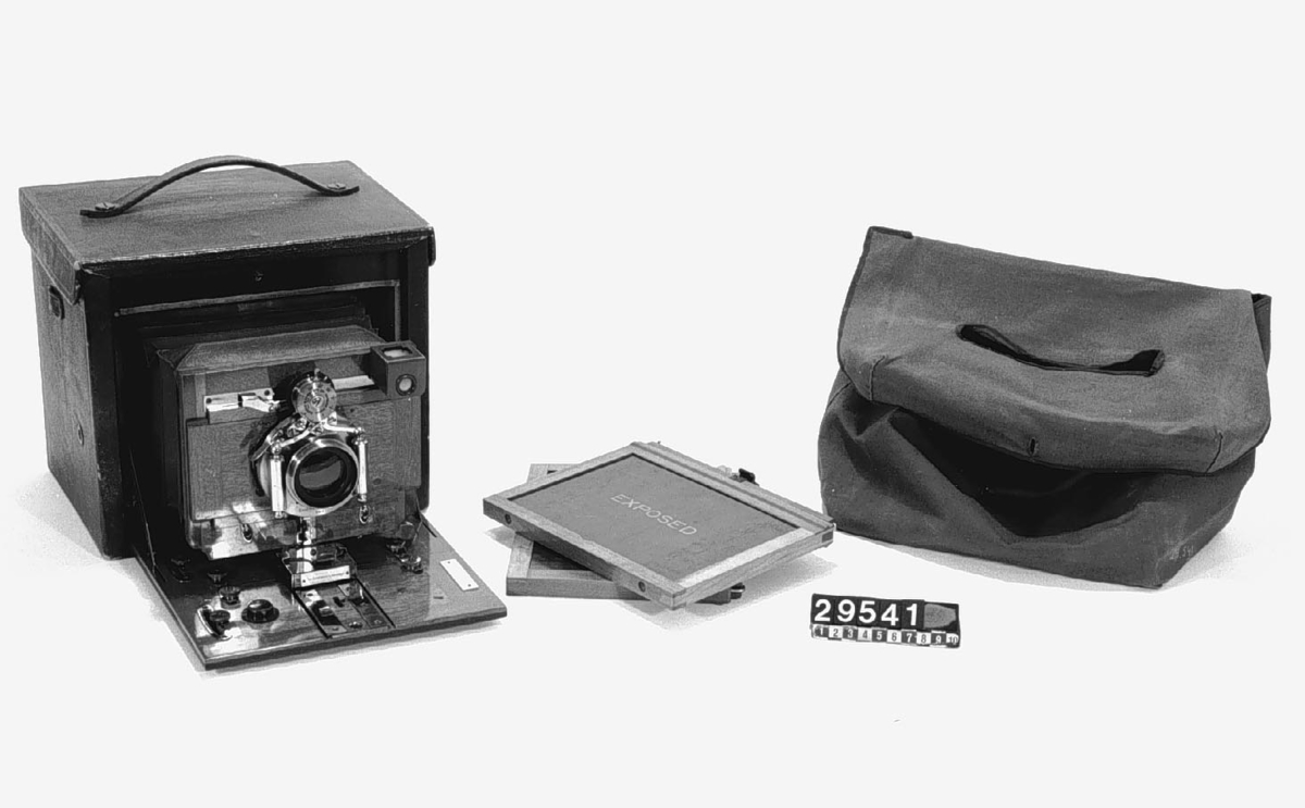 Klappkamera. Folding nr. 5 för plåtar 13 x 18 cm. Objektiv: Eastman Kodak Co. Pegamoidklätt kamerahus.
Tillbehör: Tygfodral och 2 st. lösa träkassetter.