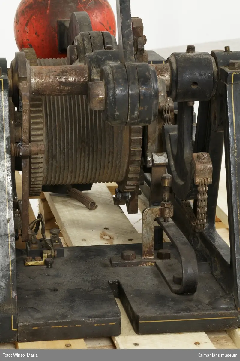 KLM 8522:1-4. Klämtmaskin, med vikter. Fyra delar. Användes för att klämta i klocka vid brand. Klämtmaskin (:1) av metall; järn, stål och mässing. Ramen är målad svart med guldfärgade dekorlinjer. På ena sidan är tillverkarens namn gjutet i järnet: L.M. ERICSSON & C STOCKHOLM. Maskinen dras upp för hand genom en vev som sitter på ena sidan, handtaget saknas. Vid uppdragningen vevas en vajer runt kugghjulet. I ena änden av maskinen en platta med detaljer av mässing där elektricitet kopplades in. Genom att trycka på en knapp startades maskinen elektriskt och mekaniken drog igång så att den orangefärgade kläppen slog upp i klockan. Enligt L.M Ericssons produktktalog från år 1889 kunde maskinen ge ca. 80 klämtslag på en uppdragning. 

Till maskinen hör två vikter med tillhörande viktskivor. Den största vikten (:2) med tillhörande viktskivor (:2:1-6) hängde i en krok vid maskinens ena kortände. Den andra vikten (:3), som är försedd med en fjädring, hängde i vajerns ena ände och kunde justeras med tillhörande viktskivor (:3:1-10). Till maskinen hör också en talja med väggställning (:4), som vajern gick genom. Alla lösa delar till maskinen är av järn och är målade med en blank, svart färg.